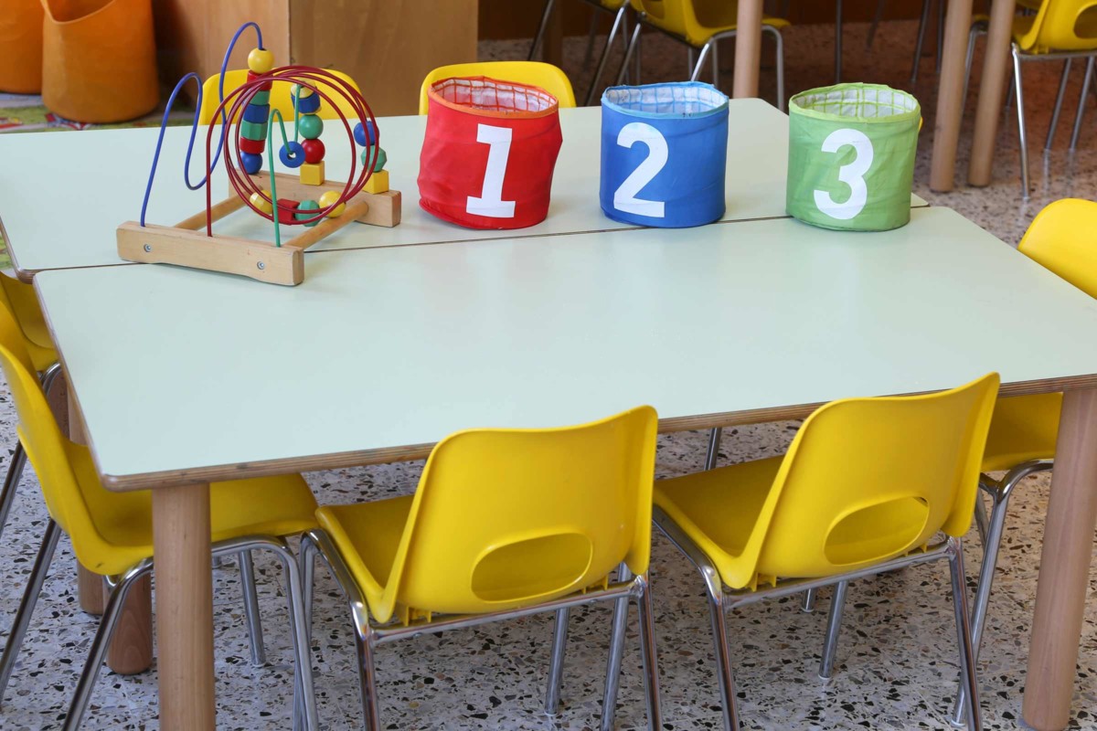 Preschool classroom. Image focused on one table with buckets labeled 1, 2, 3