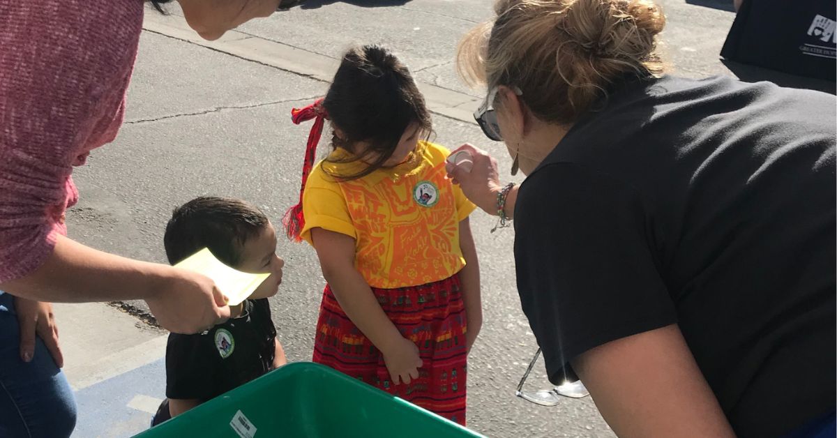 A young child receives a sticker at an outdoor resource fair.