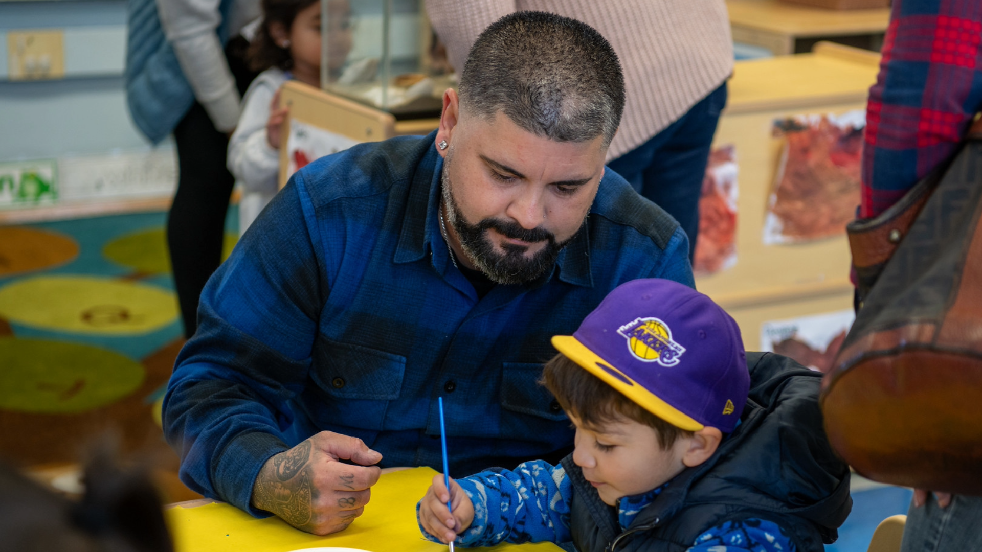 A father and small child work together on a painting.