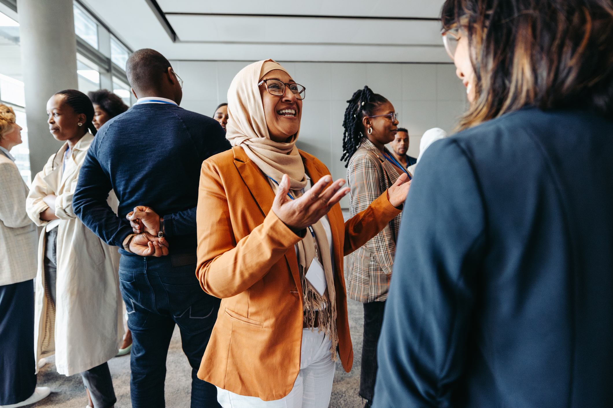 Smiling woman sharing and talking with colleagues at a networking event. Professional women engaging in a lively conversation.